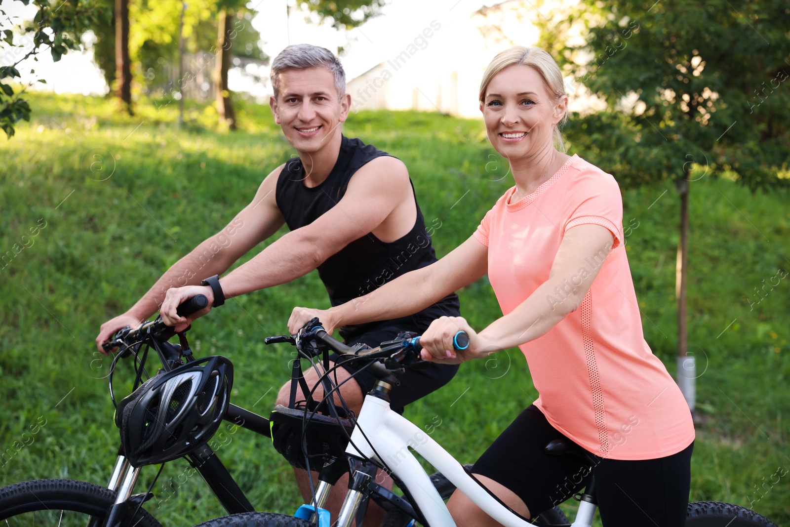 Photo of Happy couple riding bicycles in park. Healthy lifestyle