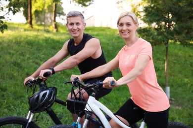 Happy couple riding bicycles in park. Healthy lifestyle