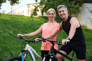 Happy couple riding bicycles in park. Healthy lifestyle