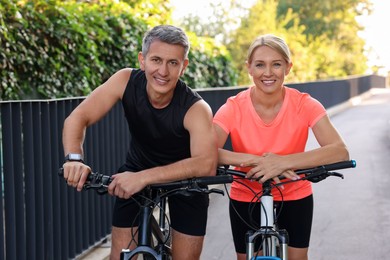 Happy couple with bicycles in park. Healthy lifestyle