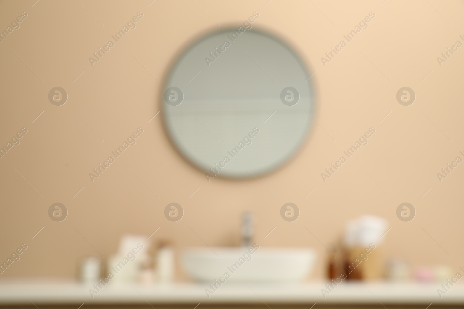 Photo of Blurred view of countertop with sink, toiletries and mirror in bathroom