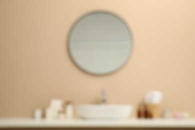 Photo of Blurred view of countertop with sink, toiletries and mirror in bathroom