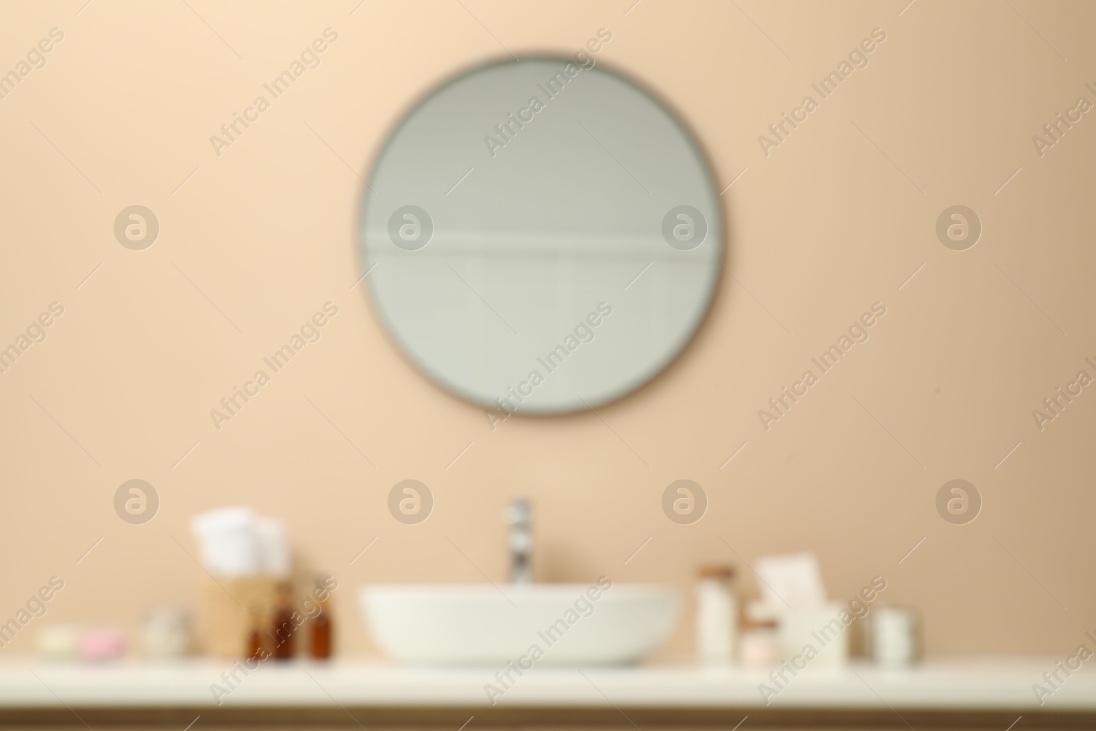 Photo of Blurred view of countertop with sink, toiletries and mirror in bathroom