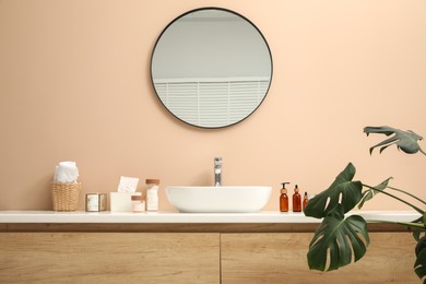 Photo of Countertop with sink, toiletries and mirror in bathroom