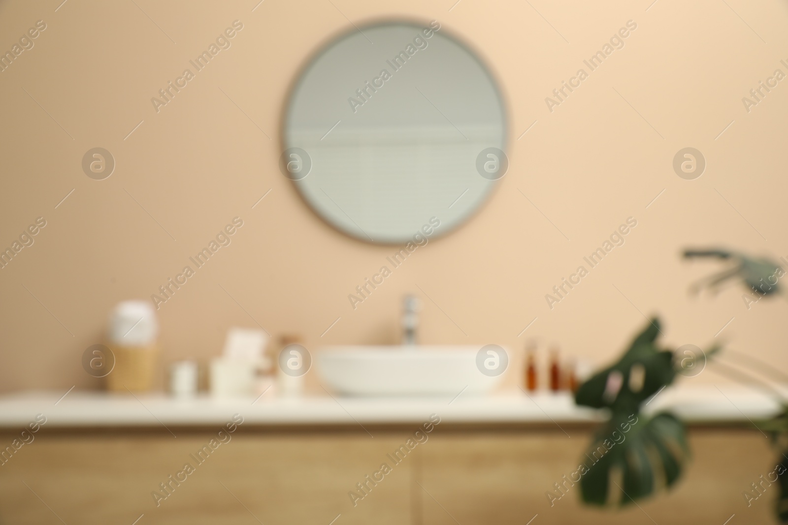 Photo of Blurred view of countertop with sink, toiletries and mirror in bathroom