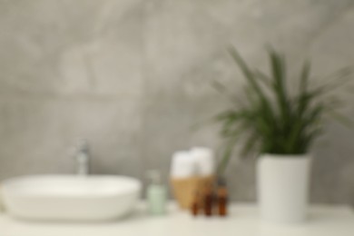 Photo of Blurred view of countertop with sink and toiletries in bathroom