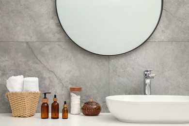 Photo of Countertop with sink, toiletries and mirror in bathroom