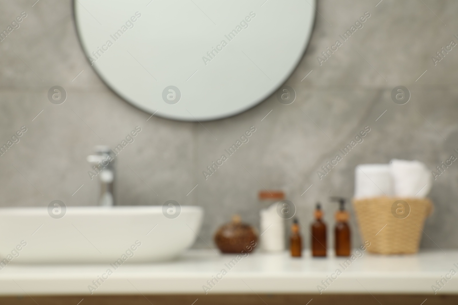 Photo of Blurred view of countertop with sink, toiletries and mirror in bathroom