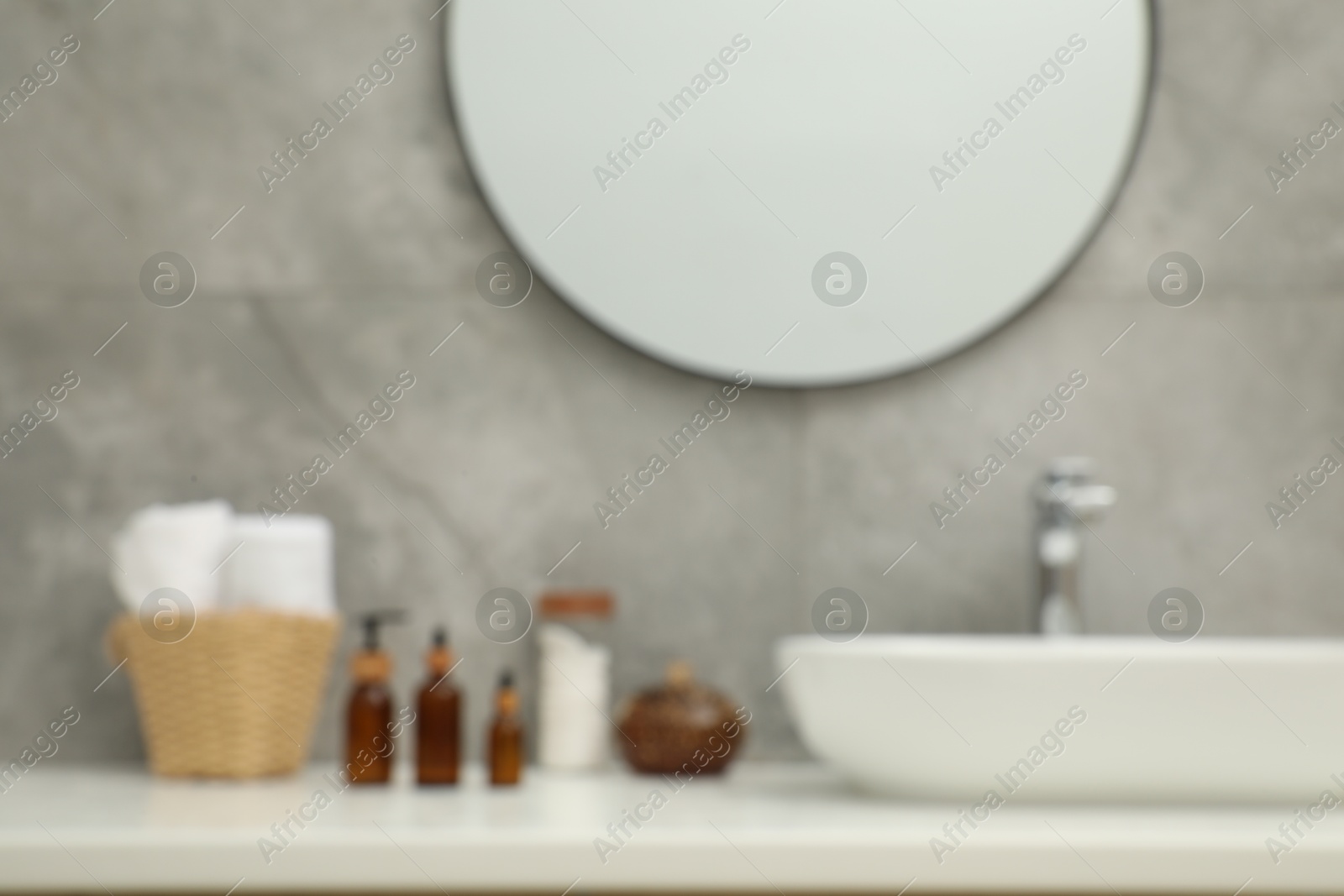 Photo of Blurred view of countertop with sink, toiletries and mirror in bathroom