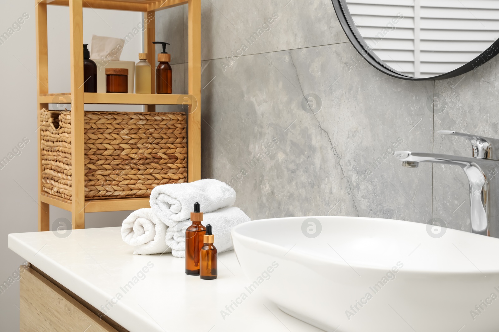 Photo of Vanity with sink, towels and shelving unit in bathroom