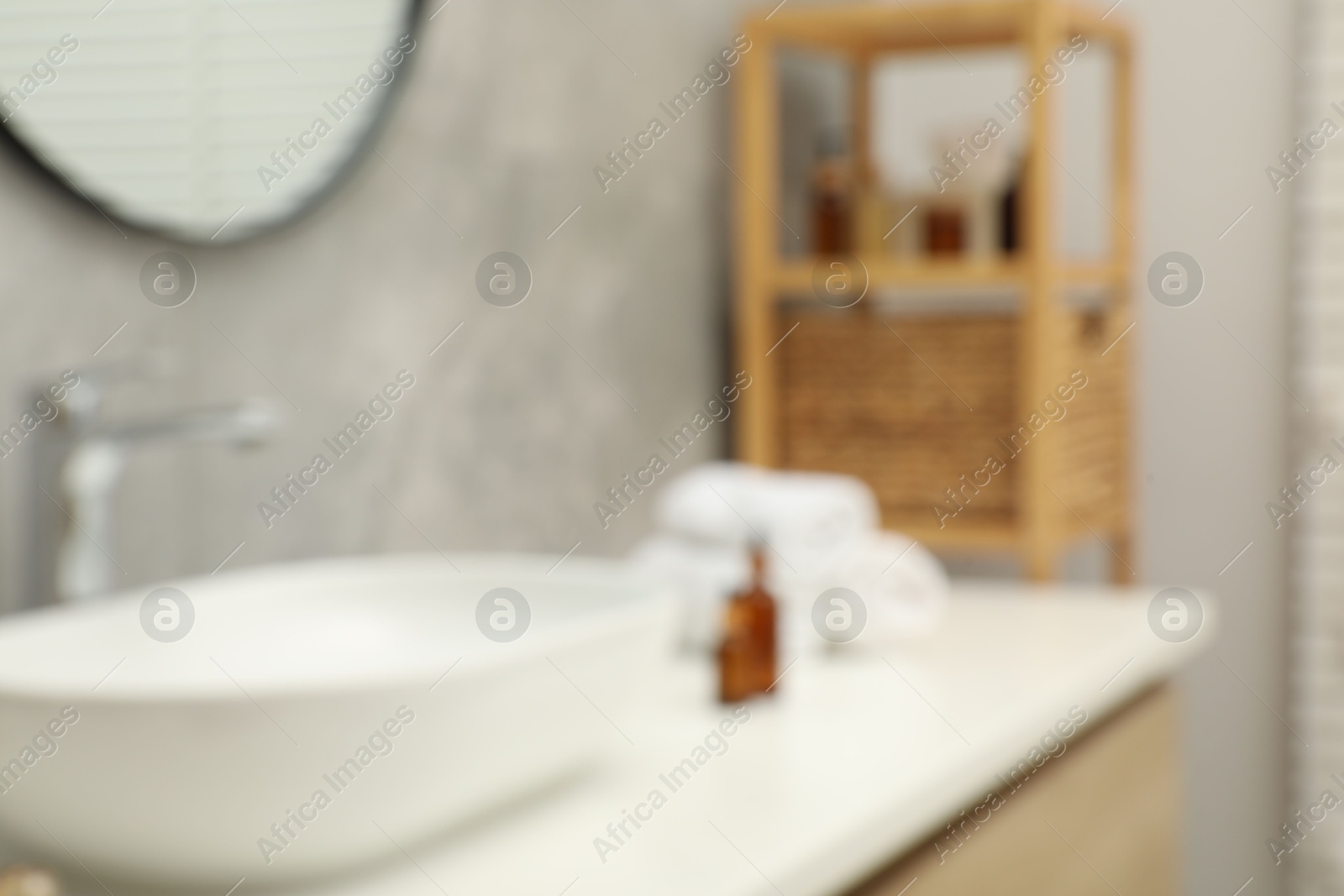 Photo of Blurred view of vanity with sink, towels and shelving unit in bathroom