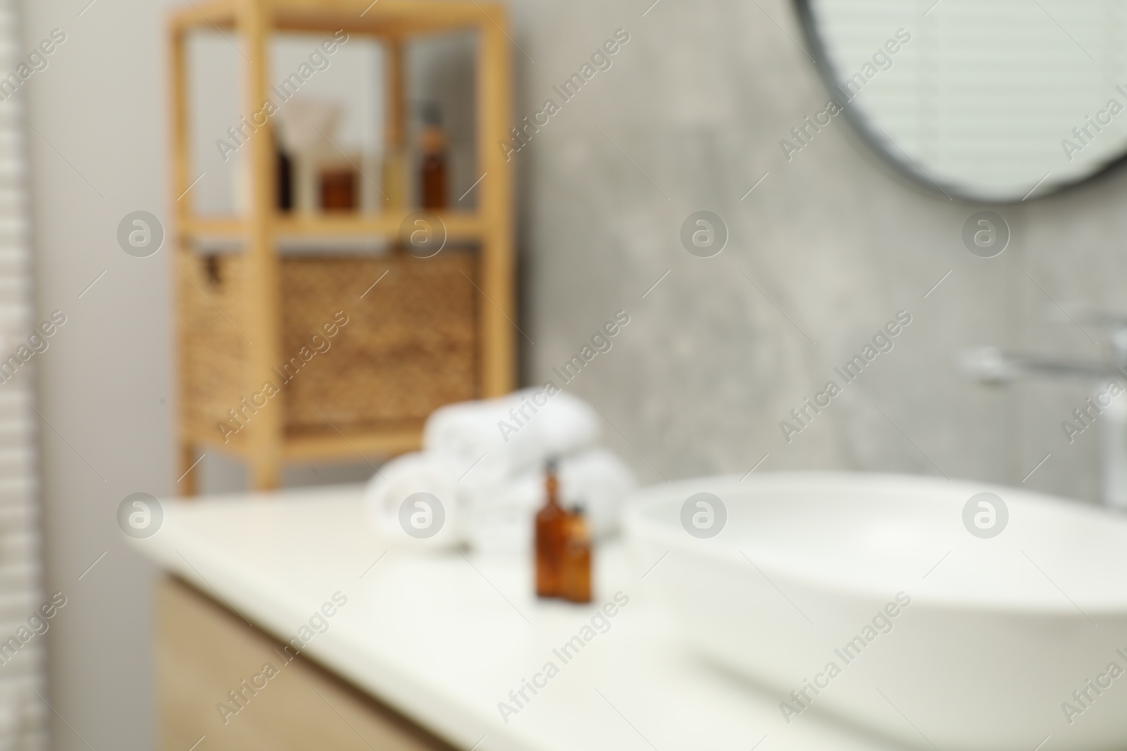 Photo of Blurred view of vanity with sink, towels and shelving unit in bathroom