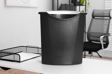 Photo of Paper shredder with bin on white table in office