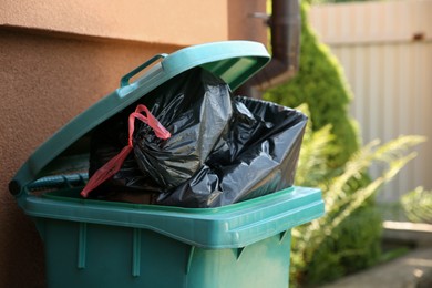 Trash bags full of garbage in bin outdoors, space for text