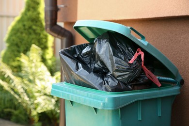 Photo of Trash bags full of garbage in bin outdoors, space for text