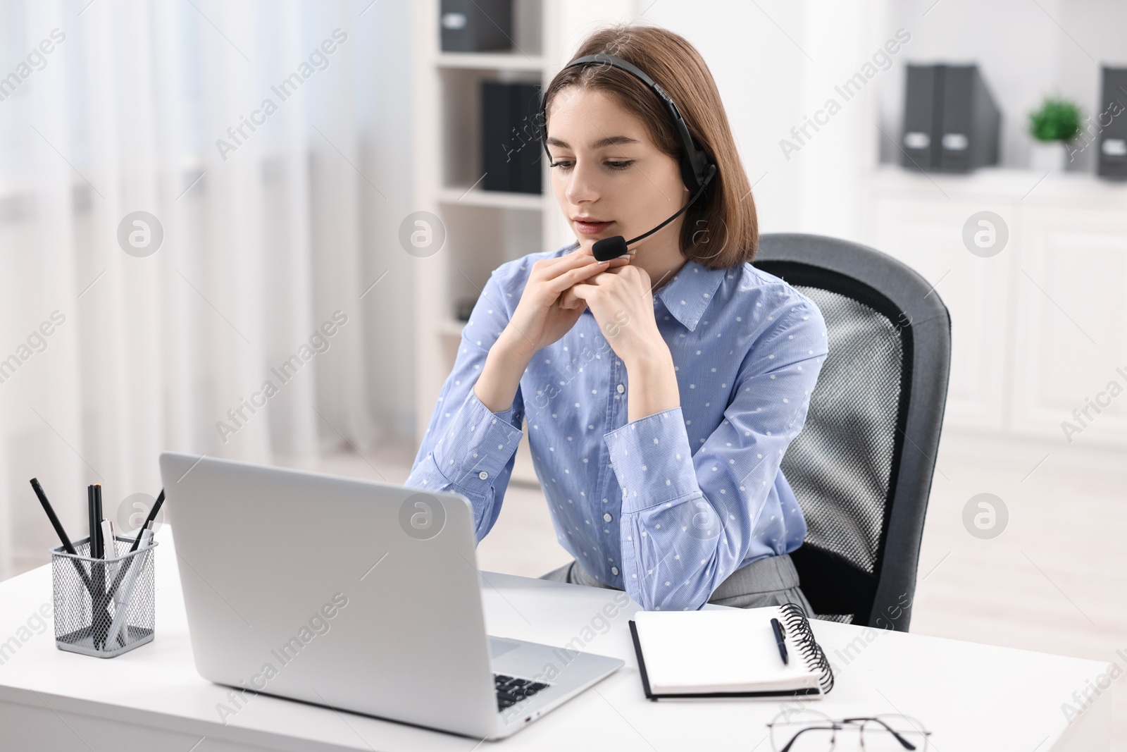 Photo of Teenager in headset having video chat via laptop at home. Remote work