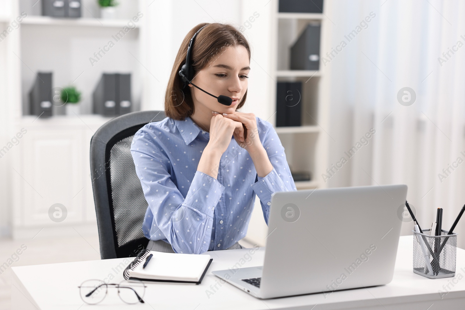 Photo of Teenager in headset having video chat via laptop at home. Remote work