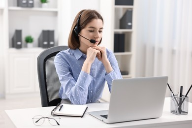 Teenager in headset having video chat via laptop at home. Remote work