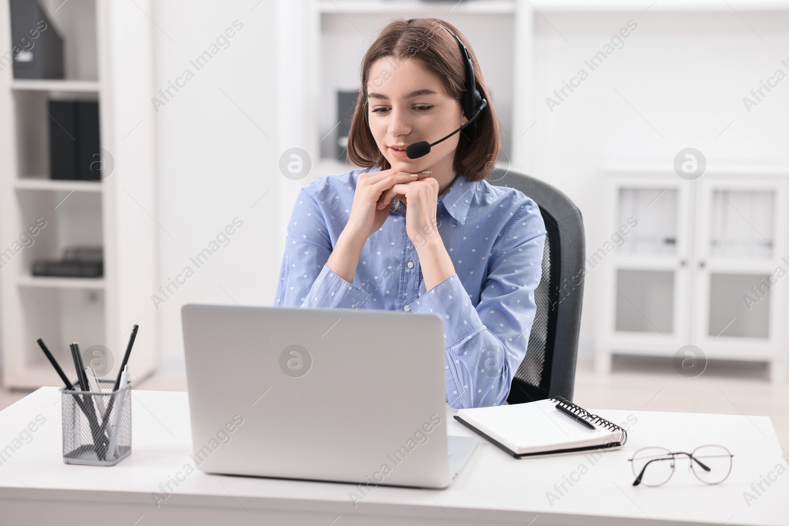 Photo of Teenager in headset having video chat via laptop at home. Remote work