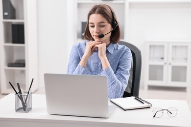 Photo of Teenager in headset having video chat via laptop at home. Remote work