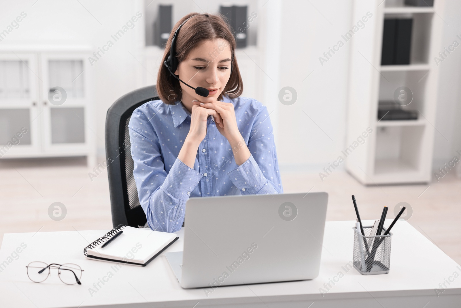 Photo of Teenager in headset having video chat via laptop at home. Remote work