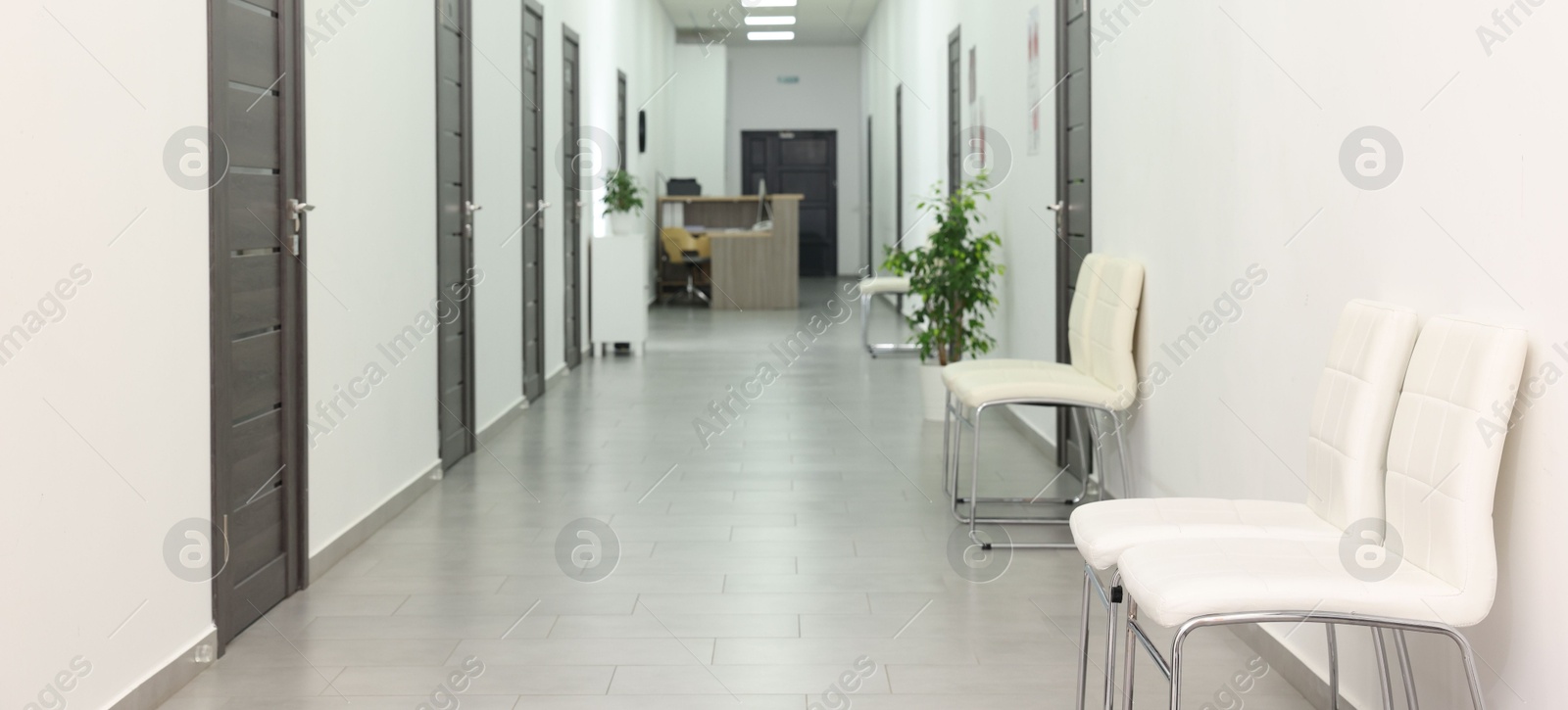 Photo of Empty hospital corridor with chairs and doors