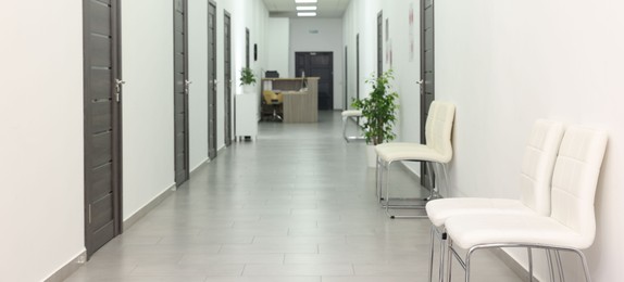 Photo of Empty hospital corridor with chairs and doors