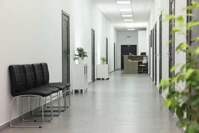 Empty hospital corridor with chairs and doors