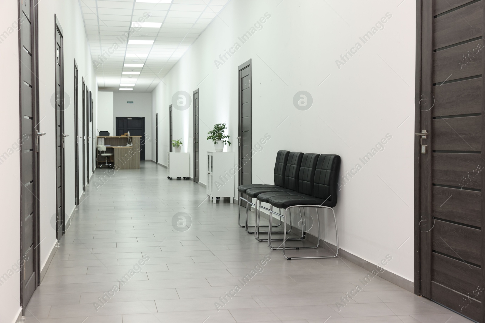 Photo of Empty hospital corridor with chairs and doors