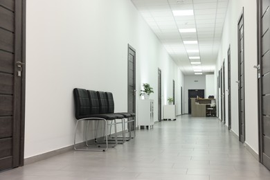 Empty hospital corridor with chairs and doors