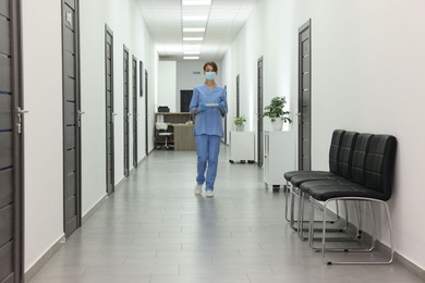 Photo of Nurse in uniform walking in hospital hallway