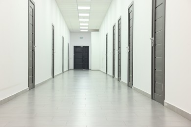 View of empty hospital corridor with wooden doors