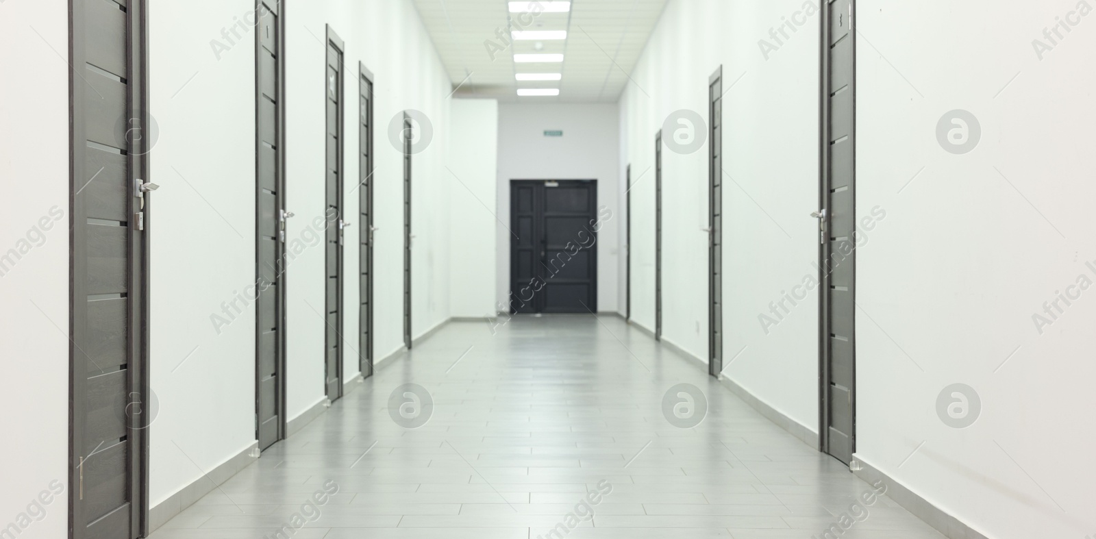 Photo of View of empty hospital corridor with wooden doors