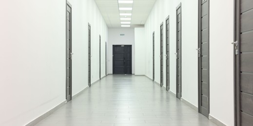 View of empty hospital corridor with wooden doors