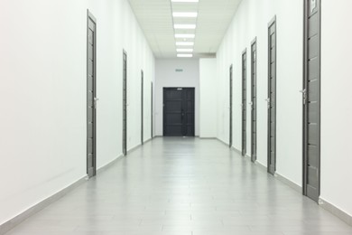 View of empty hospital corridor with wooden doors