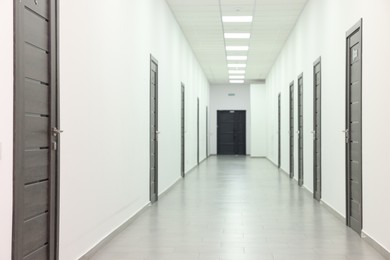 View of empty hospital corridor with wooden doors