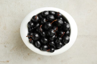 Photo of Ripe black currants in bowl on light table, top view