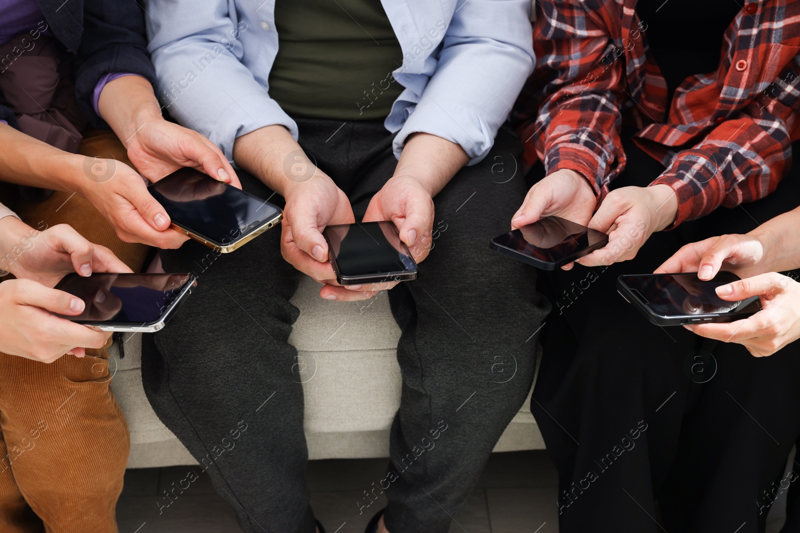 Photo of People holding smartphones with blank screens indoors, closeup