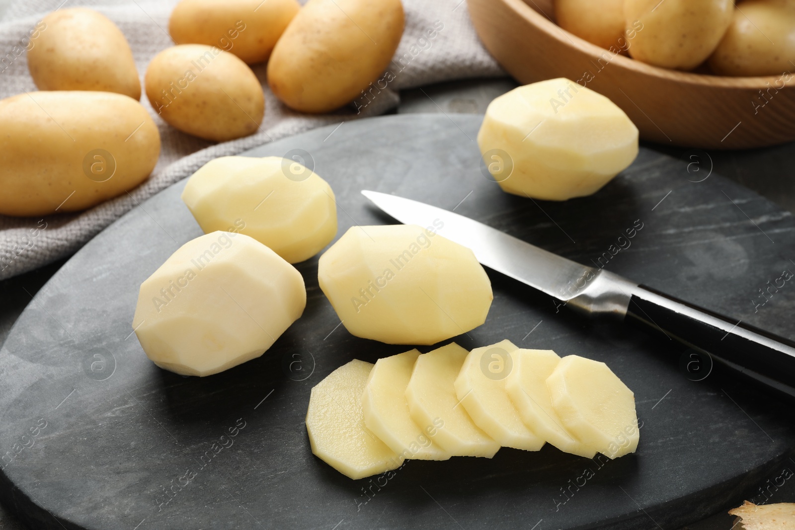 Photo of Fresh raw potatoes and knife on table