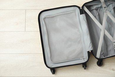 Photo of Open empty suitcase on floor indoors, top view. Space for text