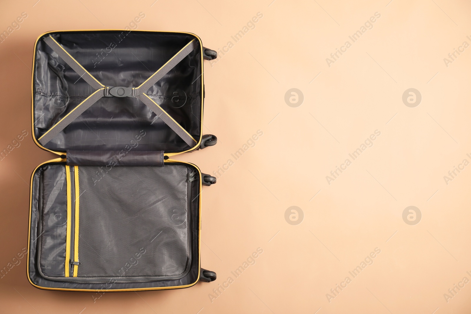 Photo of Open empty suitcase on beige background, top view. Space for text