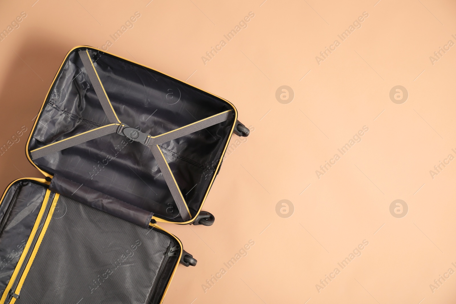 Photo of Open empty suitcase on beige background, top view. Space for text