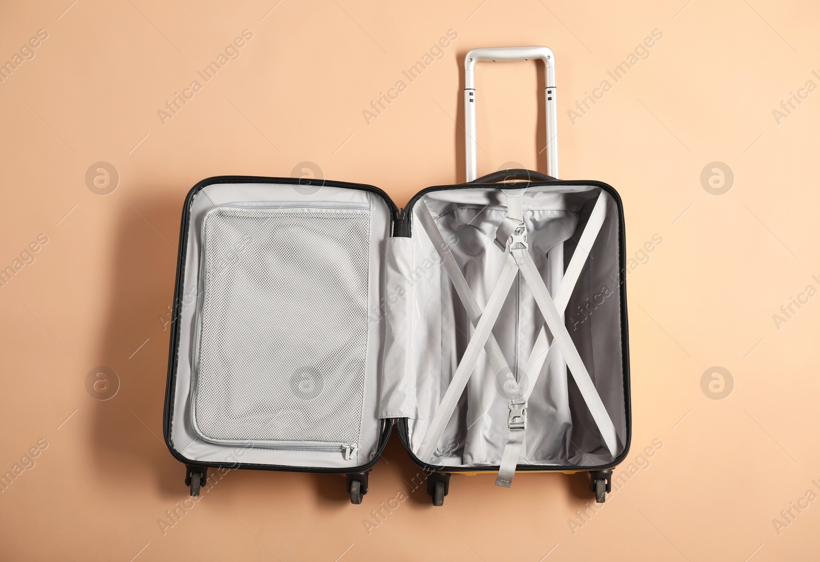 Photo of Open empty suitcase for travelling on beige background, top view