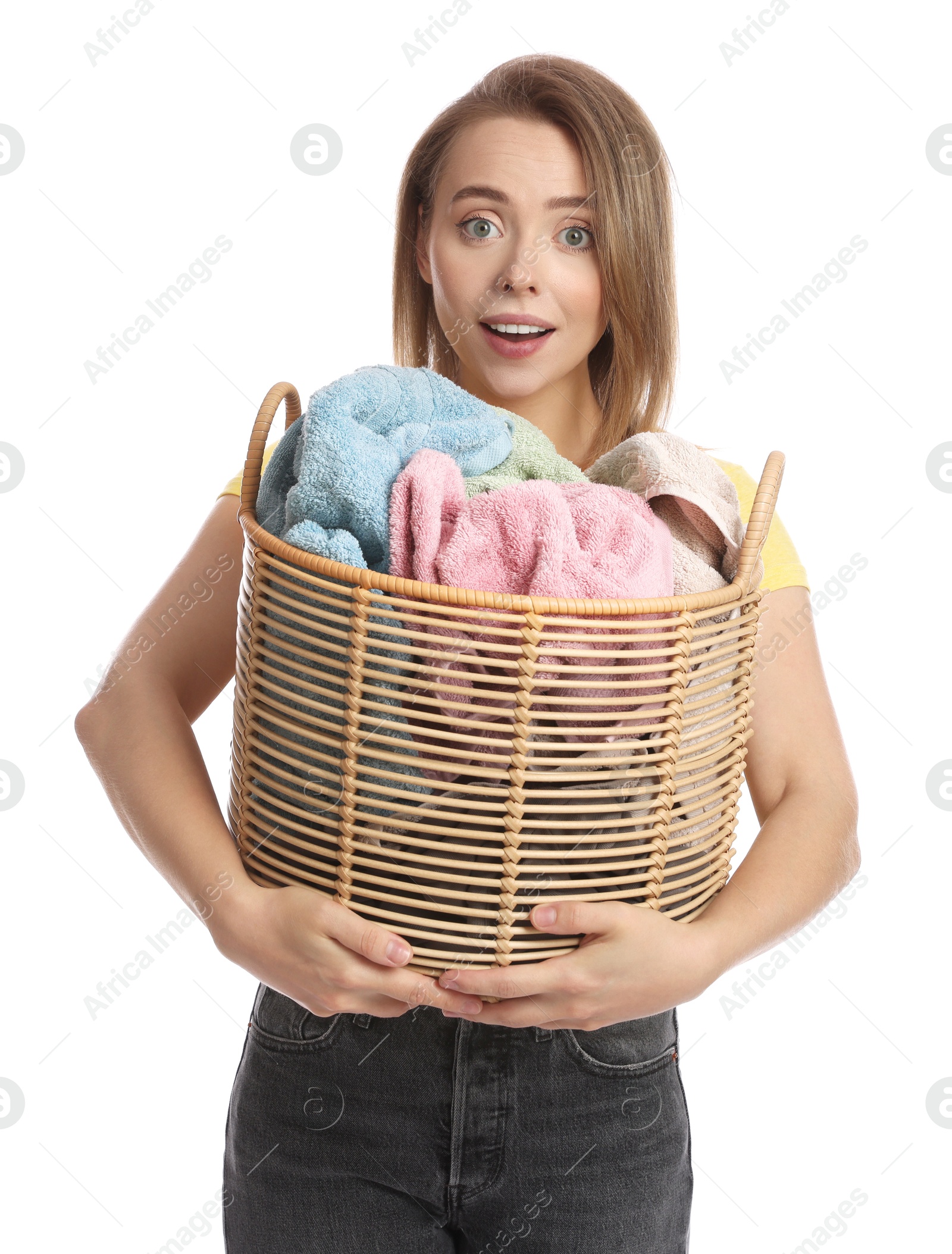 Photo of Happy young housewife with basket full of laundry on white background