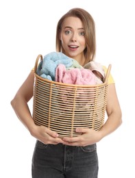 Photo of Happy young housewife with basket full of laundry on white background