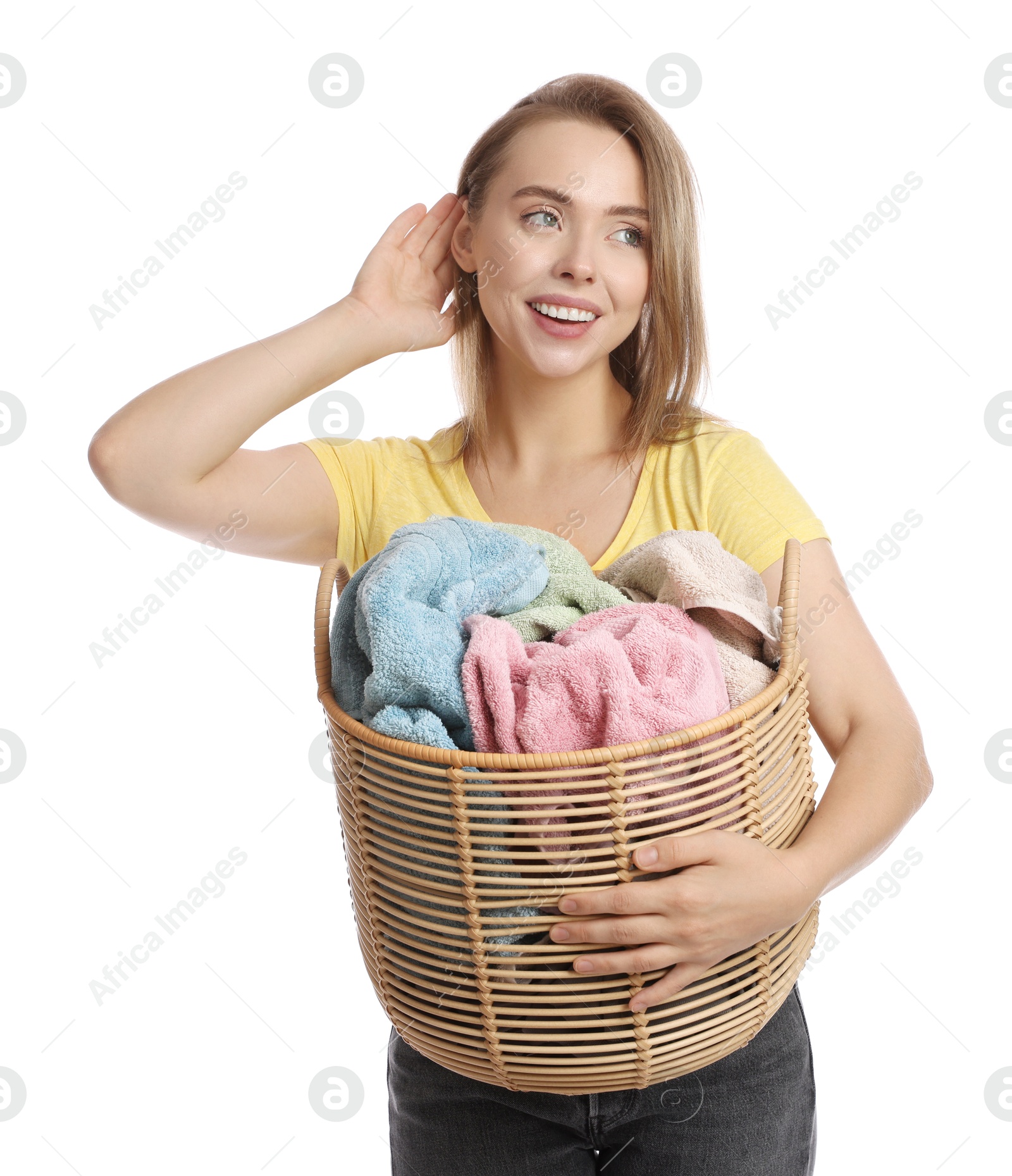 Photo of Happy young housewife with basket full of laundry on white background