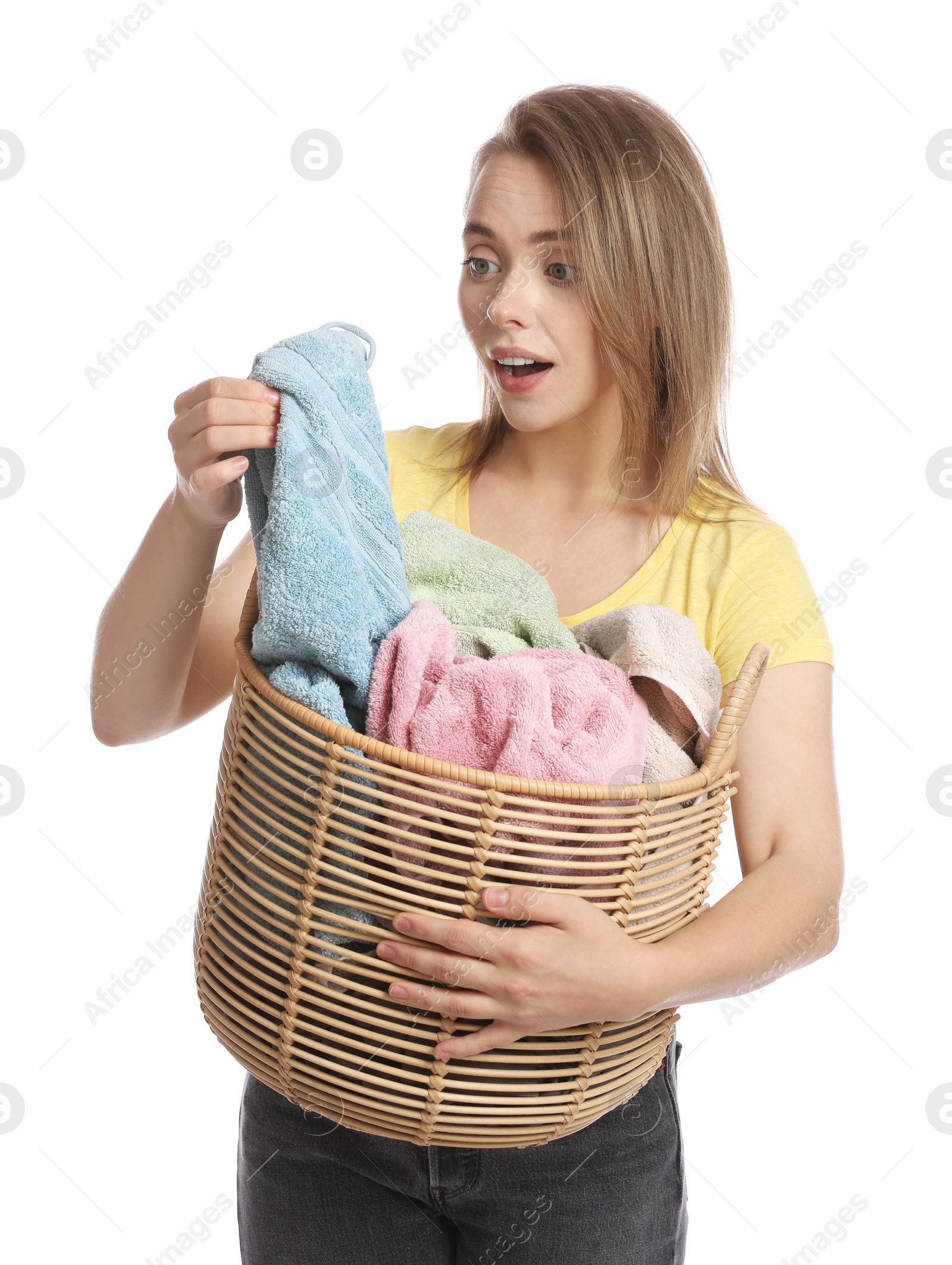 Photo of Happy young housewife with basket full of laundry on white background