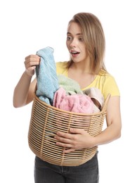 Photo of Happy young housewife with basket full of laundry on white background