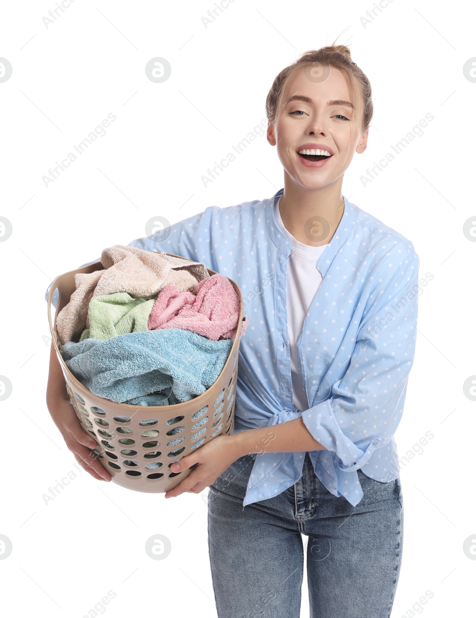 Photo of Happy young housewife with basket full of laundry on white background