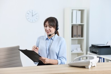 Photo of Professional receptionist working at wooden desk in office